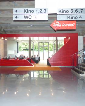 das rote Passepartout grenzt die Lounge bewusst zur Halle hin ab