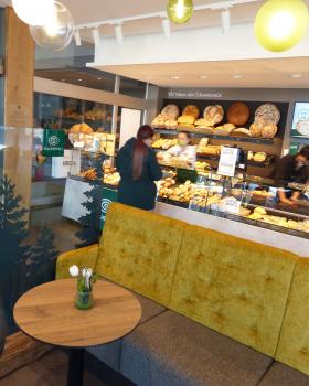 Eine lange Sitzbank teilt den Café-Bereich von der Theke.