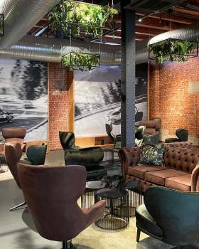 Bar mit abgehängten Pflanzkörben und verschieblichen Motivwänden vor den Rolltoren